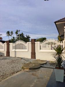 une clôture blanche devant une maison dans l'établissement Glamstay BatuRakit by Beach (Netflix,Umt,Unisza,Ipg), à Kuala Terengganu