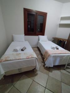 two beds sitting next to each other in a room at Recanto Pau Brasil in Sete Lagoas