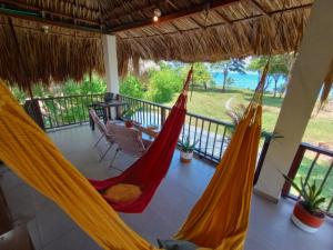 um quarto com duas redes de descanso numa varanda em Deluxe Family Suite - In front of the sea em Moñitos
