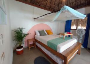 um quarto com uma cama e uma ventoinha. em Deluxe Family Suite - In front of the sea em Moñitos