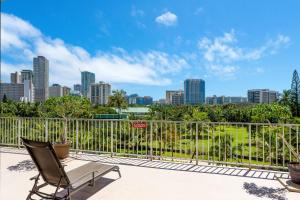 a chair sitting on a balcony with a city skyline at Waikiki condo -18F in Honolulu