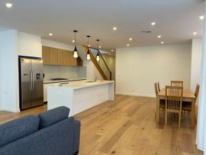 a living room and kitchen with a couch and a table at New 2-story house with 4 bedrooms and 3 shower rooms in Burwood