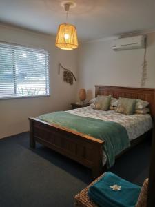 a bedroom with a large bed and a window at Aqua Shack Jurien Bay in Jurien Bay