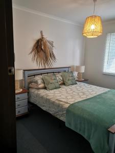 a bedroom with a bed and a chandelier at Aqua Shack Jurien Bay in Jurien Bay