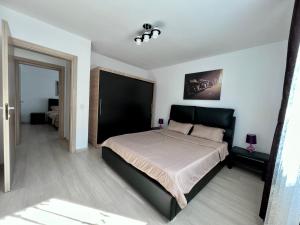 a bedroom with a large bed with a black headboard at Trippin Iasi Apartament in Iaşi