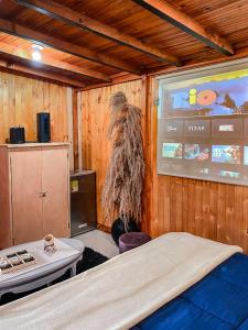 a bedroom with a large screen with a costume on the wall at cabaña el zapato in Suesca