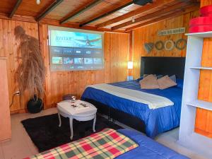 a bedroom with a bed and a table and a tv at cabaña el zapato in Suesca