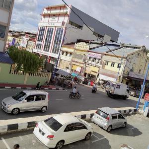 two cars parked on a street in a city at Happy Bentong Guest House in Bentong