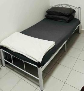 ein Bett mit einer schwarz-weißen Matratze darauf in der Unterkunft Afrinas Homestay @ Banting in Banting