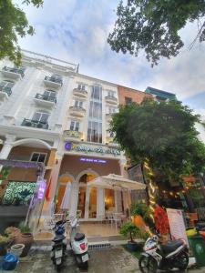 a white building with motorcycles parked in front of it at Saigon By Night Luxury Hotel in Ho Chi Minh City