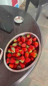 a bowl of strawberries sitting on a glass table at Tabletop Villa Standard - 3 in Panchgani