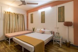 a bedroom with two beds and a ceiling fan at Tabletop Villa Standard - 3 in Panchgani
