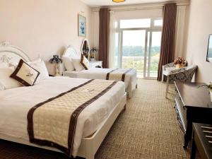 Postel nebo postele na pokoji v ubytování Ngoc Phat Dalat Hotel