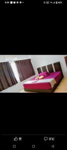 a picture of a bedroom with a bed with pink sheets at Happy Bentong Guest House in Bentong