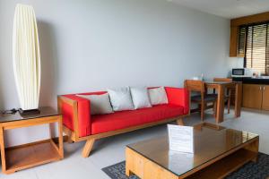 a living room with a red couch and a table at Aonang Suite Pool Villa in Ao Nang Beach