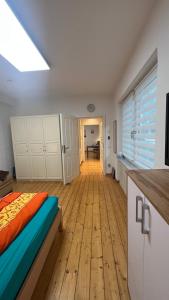 a bedroom with a bed and a wooden floor at Erdgeschoss Apartment am Park im Theaterviertel in Oberhausen in Oberhausen