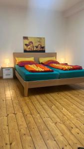 a bedroom with a bed and a wooden floor at Erdgeschoss Apartment am Park im Theaterviertel in Oberhausen in Oberhausen
