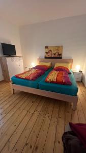 a large bed in a room with a wooden floor at Erdgeschoss Apartment am Park im Theaterviertel in Oberhausen in Oberhausen