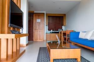 a living room with a blue couch and a tv at Aonang Suite Pool Villa in Ao Nang Beach