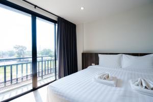 a bedroom with a bed and a large window at JS HOTEL in Hat Yai