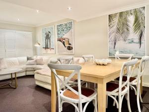 a living room with a table and a couch at Oaks Pacific Blue 349 fantastic pool in Salamander Bay