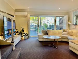 a living room with a couch and a table at Oaks Pacific Blue 349 fantastic pool in Salamander Bay