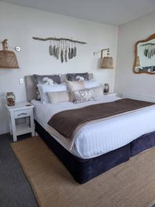 a large bed in a white bedroom with two lamps at Baragoola Retreat - Luxury Waterfront Property in Sandford
