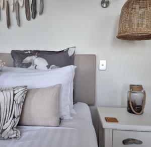 a bedroom with a bed with white sheets and a night stand at Baragoola Retreat - Luxury Waterfront Property in Sandford