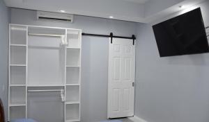 un armario con TV y una puerta blanca en Departamento María. La Crucecita Huatulco., en Santa Cruz Huatulco