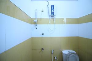 La salle de bains est pourvue d'une douche et de toilettes. dans l'établissement White House Holiday Resort, à Matara