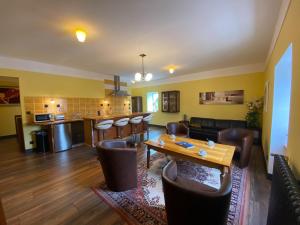 sala de estar con mesa y sillas y cocina en Comfortable holiday apartment on the 2nd floor of an elegant manor house, en Coutances