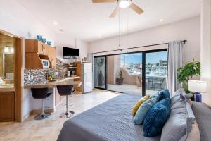 a bedroom with a bed and a kitchen with a view at Marina Cabo Plaza Town & Beach Condos in Cabo San Lucas