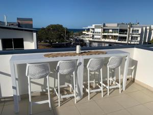 a bar on a balcony with four chairs at 347 Paradiso Kingscliff Beach 3 Bedroom Private Rooftop in Kingscliff