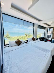 Duas camas num quarto com uma janela grande em Ninh Chu Hotel em Phan Rang