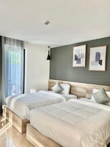 2 Betten in einem Schlafzimmer mit weißer Bettwäsche in der Unterkunft La Sera Suites Nha Trang in Nha Trang