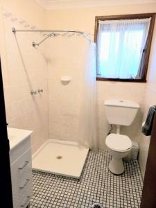 a white bathroom with a toilet and a shower at 2 Bedroom Self Contained Unit in Gloucester