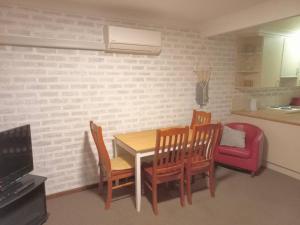 a small kitchen with a table and chairs and a couch at 2 Bedroom Self Contained Unit in Gloucester