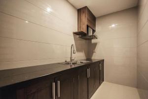 eine Küche mit Holzschränken und einem Waschbecken in der Unterkunft La Sera Suites Nha Trang in Nha Trang
