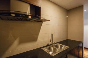 a kitchen with a sink and a microwave at La Sera Suites Nha Trang in Nha Trang