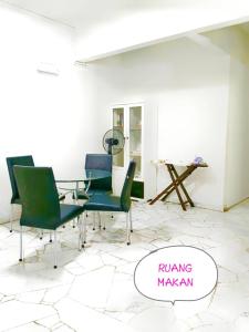 a dining room with green chairs and a table at Muslim Guest House near USM Spice Arena Gelugor Georgetown in Gelugor