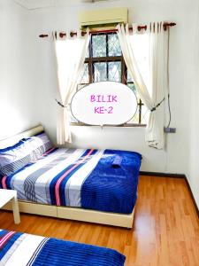 a bedroom with a bed and a window with a sign at Muslim Guest House near USM Spice Arena Gelugor Georgetown in Gelugor