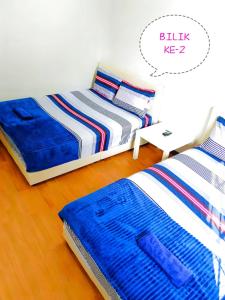 two beds sitting next to each other in a bedroom at Muslim Guest House near USM Spice Arena Gelugor Georgetown in Gelugor