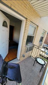 a patio with a door and a table and a bed at nice room with balcony and walking closet near Manhattan on train in Queens