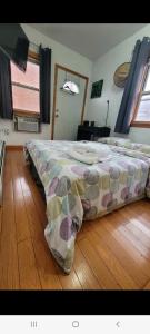 a bedroom with a bed on a wooden floor at nice room with balcony and walking closet near Manhattan on train in Queens