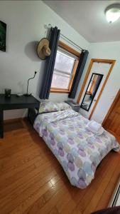 a bedroom with a bed and a desk in it at nice room with balcony and walking closet near Manhattan on train in Queens