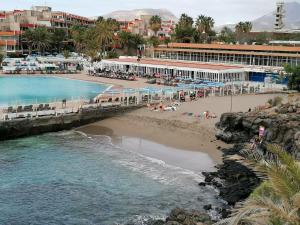 a beach with a pier and people on the sand at Captain Morgan House in Arona