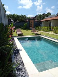a swimming pool in the backyard of a house at Parama Homestay Balangan in Uluwatu