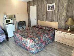 ein Hotelzimmer mit einem Bett und einer Mikrowelle in der Unterkunft Road Runner Motel Merritt BC in Merritt