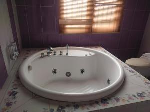 a white bath tub in a bathroom with a toilet at Traveler Guest House Yasmin Bogor Barat in Bogor