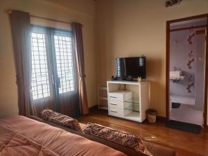 1 dormitorio con 1 cama y TV en un soporte en Traveler Guest House Yasmin Bogor Barat, en Bogor